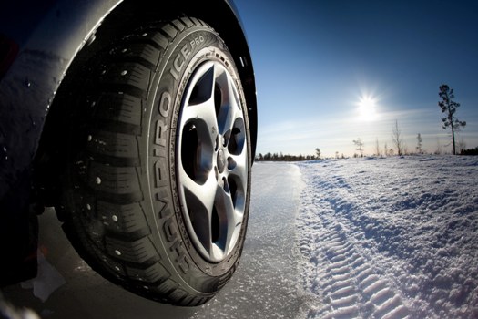 a photo of a tire next to a road shoulder with snow